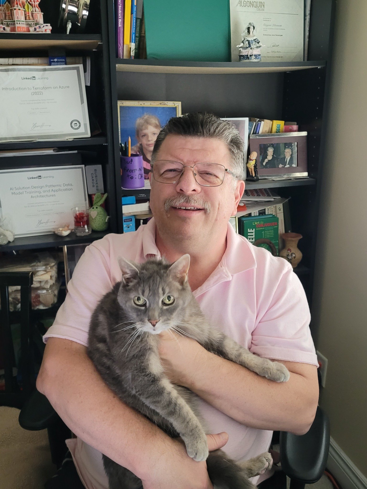 Greg Libenson holding a grey cat in his home office